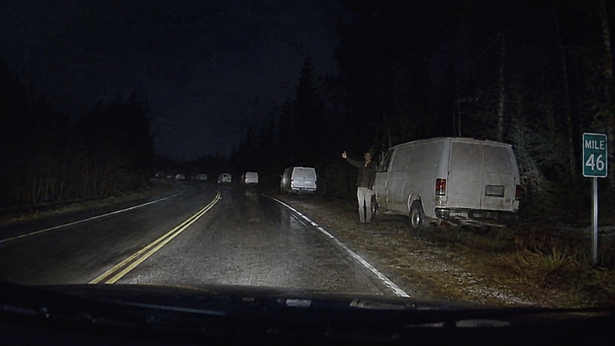 Fictional evidence image of white cargo vans appearing along a dark repeating highway near Mile 46.